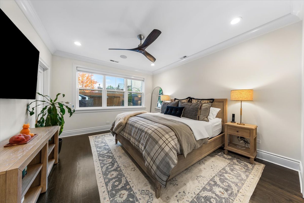 Undisclosed Address Chicago, IL 60622 - Photo 16 of 41 a spacious bedroom with a bed a flat screen tv and a potted plant