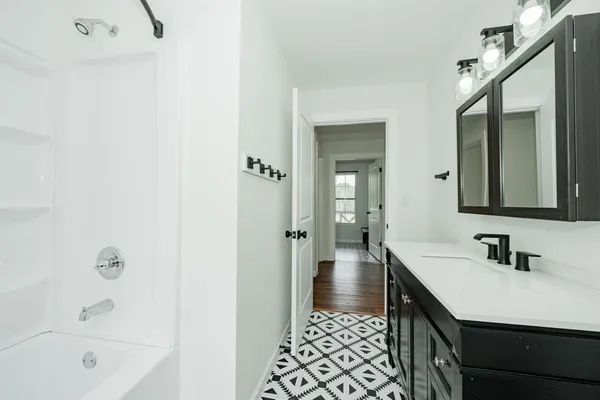 a bathroom with a sink a mirror and a bathtub