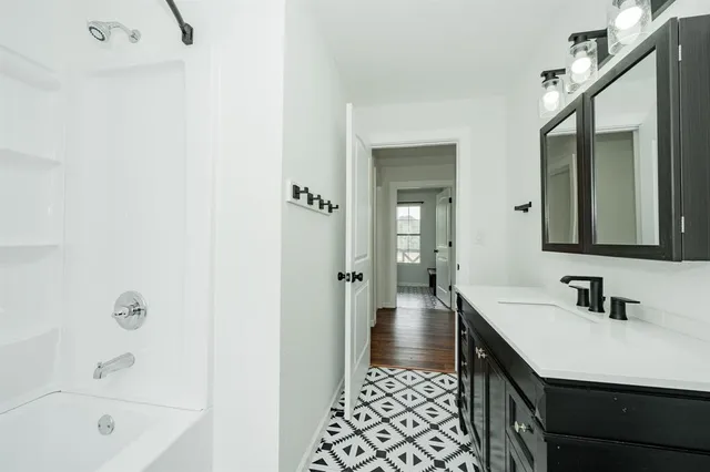 a bathroom with a sink a mirror and a bathtub