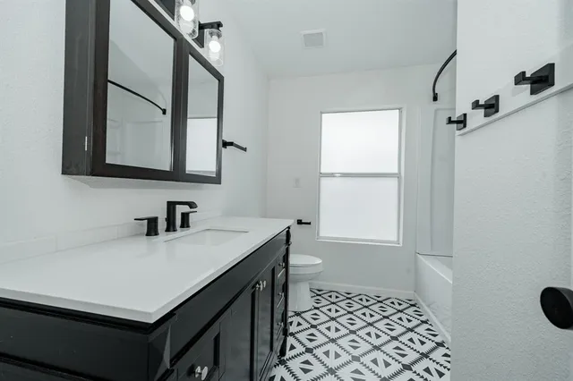 a bathroom with a sink vanity granite and a mirror