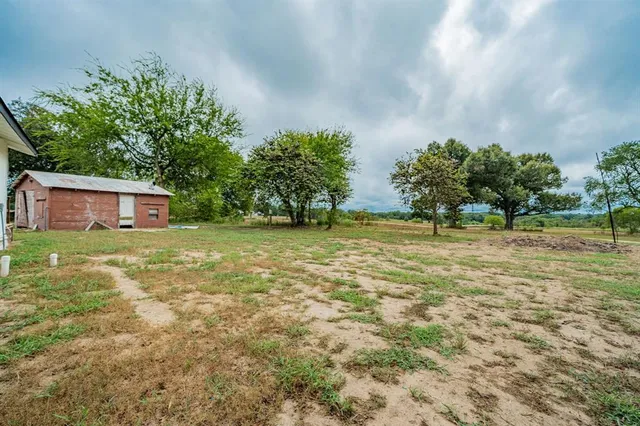 a view of a green field with trees