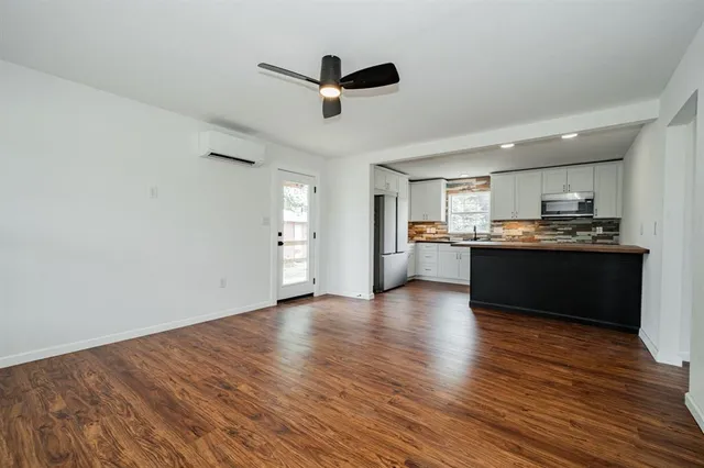 a view of kitchen with refrigerator stove and wooden floor