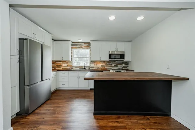 a kitchen with stainless steel appliances granite countertop a stove a refrigerator and a microwave