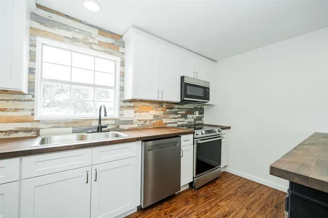 a kitchen with a sink stove top oven and microwave