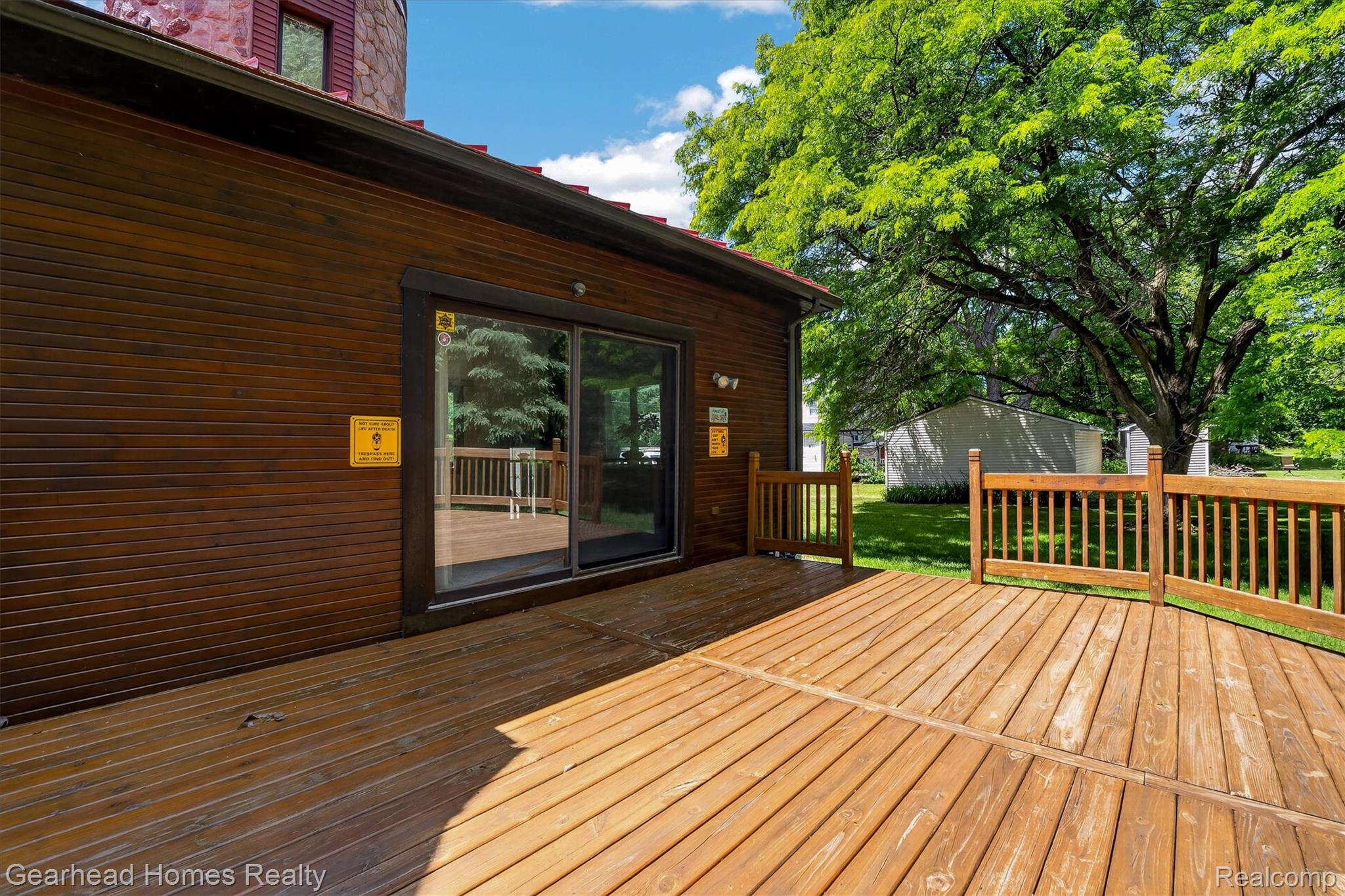 3486 West Drahner Road Oxford, MI 48371 - Photo 18 of 51 Spacious wood deck with natural wood railing, dark wood siding, and large sliding glass door