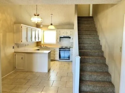 a kitchen with a sink counter top space cabinets and stainless steel appliances