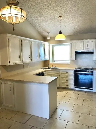 a kitchen with stainless steel appliances granite countertop a stove a sink and a microwave