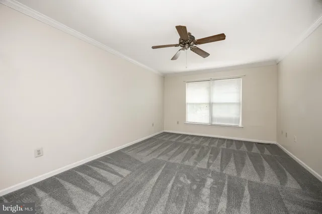 a view of empty room with ceiling fan