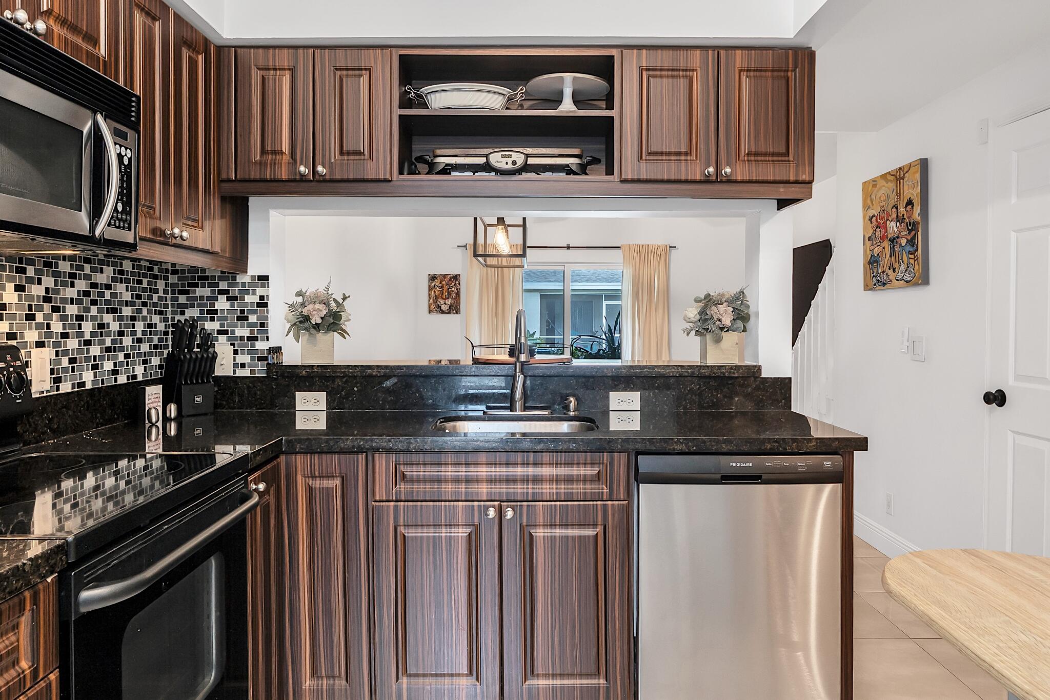 12 Fleming Court Weston, FL 33326 - Photo 13 of 51 a kitchen with stainless steel appliances granite countertop a stove a sink and a microwave
