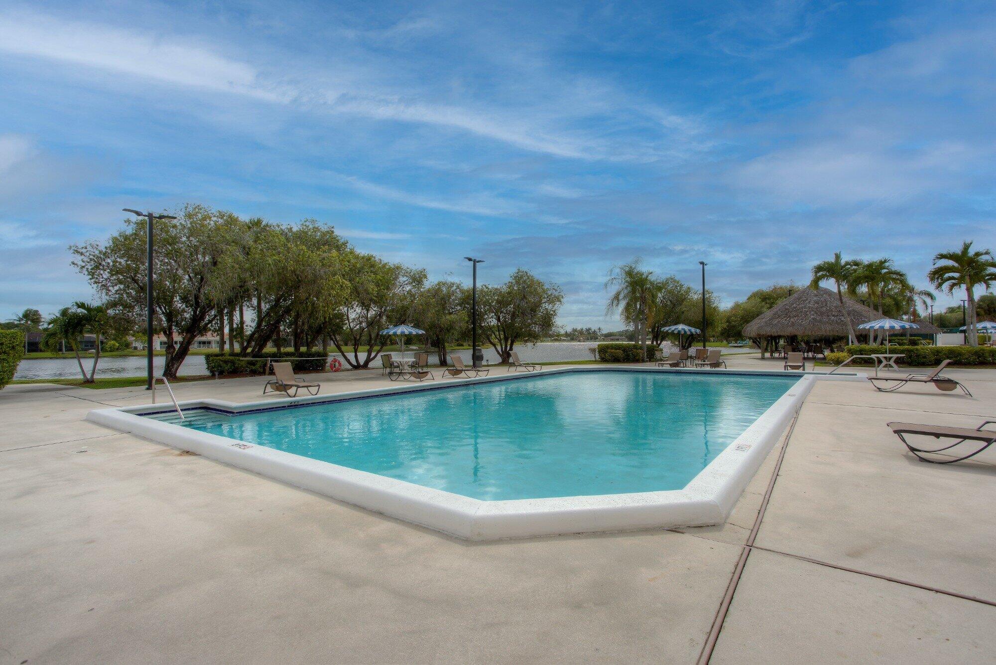 12 Fleming Court Weston, FL 33326 - Photo 50 of 51 a view of swimming pool with outdoor seating and trees in the background