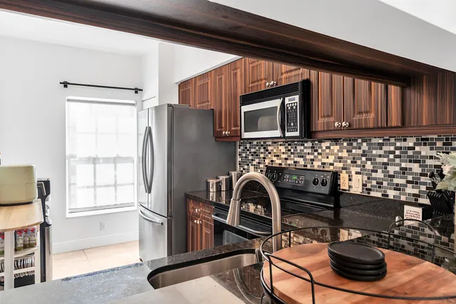 a kitchen with granite countertop a refrigerator stove and microwave