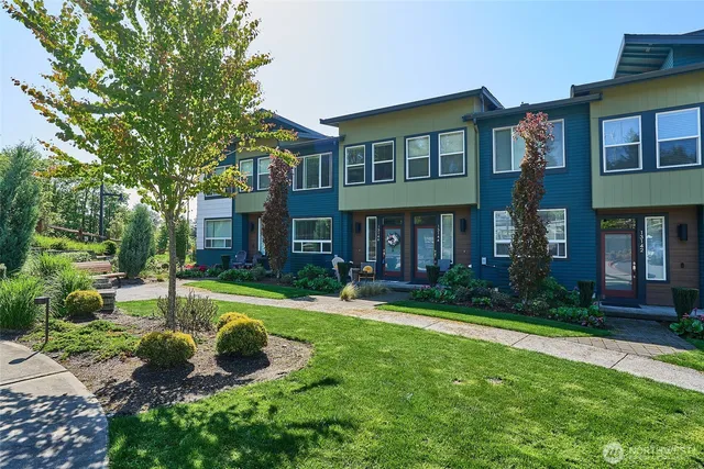 a view of a brick house with a yard and plants