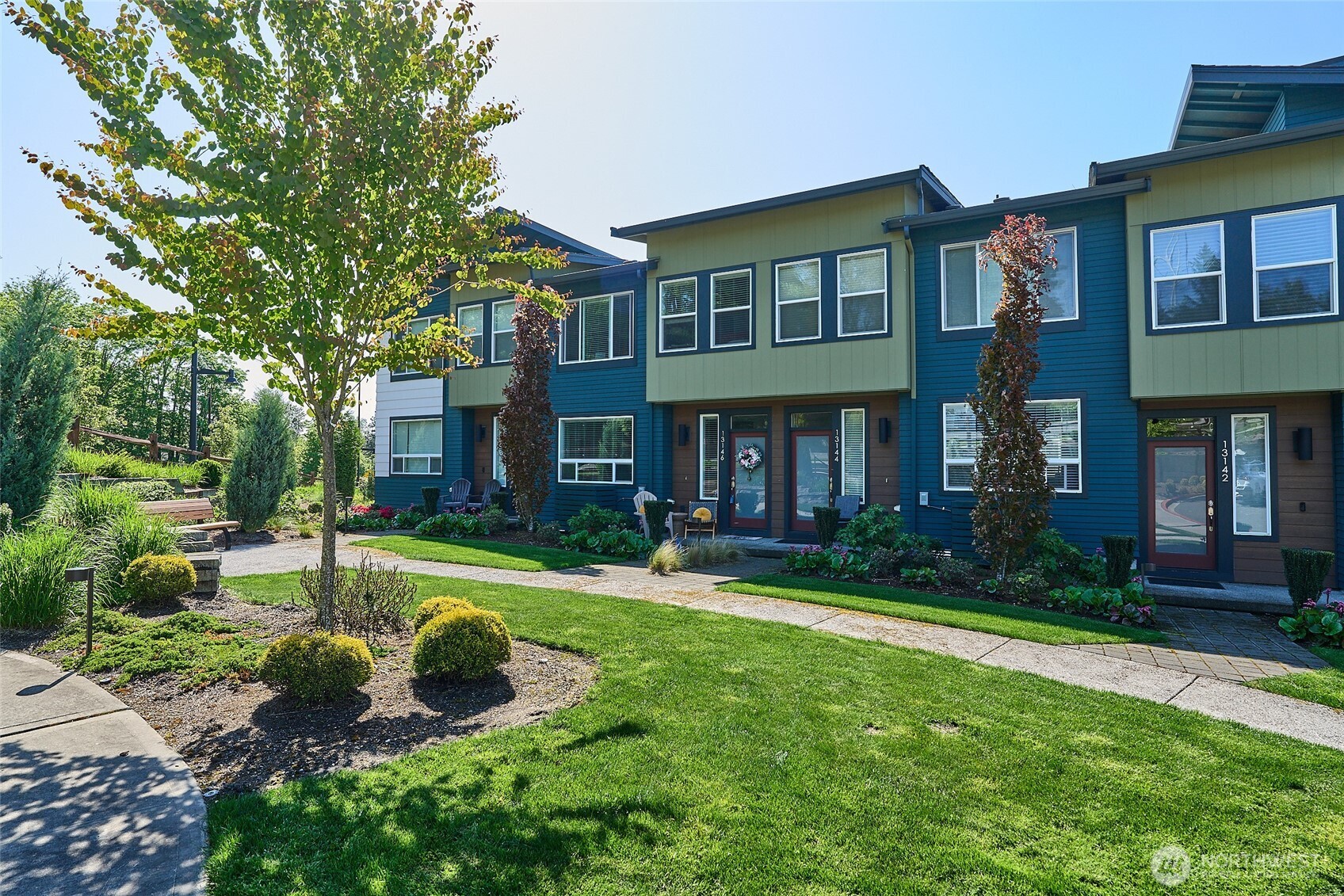 a view of a brick house with a yard and plants