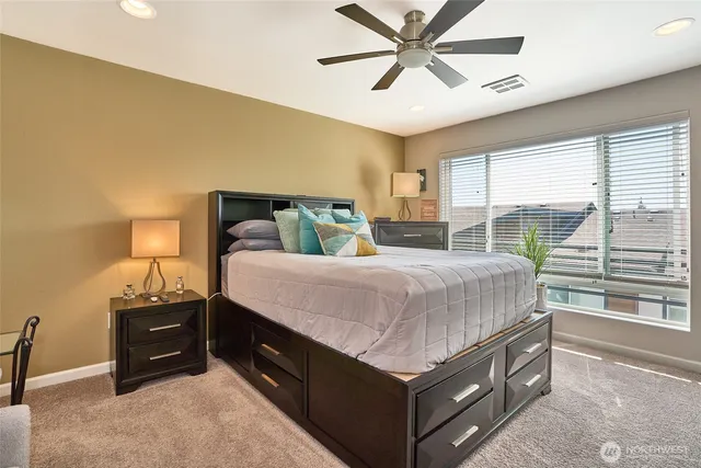 a bedroom with a bed and a large window