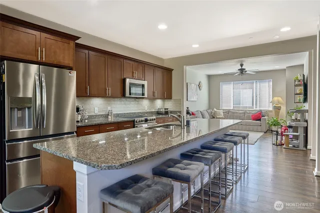 a large kitchen with granite countertop a large counter top stainless steel appliances and cabinets