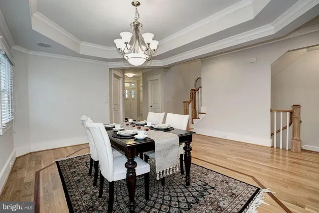 a view of a dining room with furniture a chandelier and wooden floor