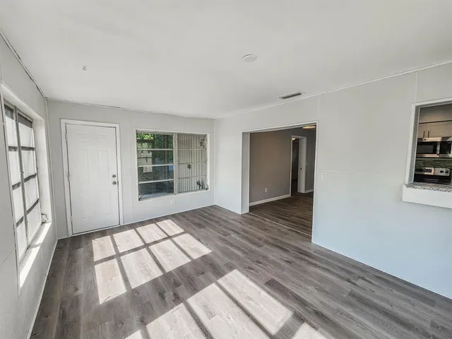 a view of a room with wooden floor and windows