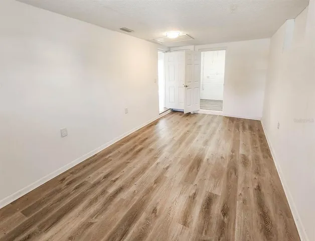 a view of room with wooden floor and white walls