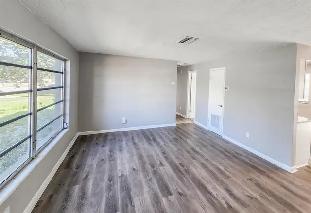 wooden floor in an empty room with a window