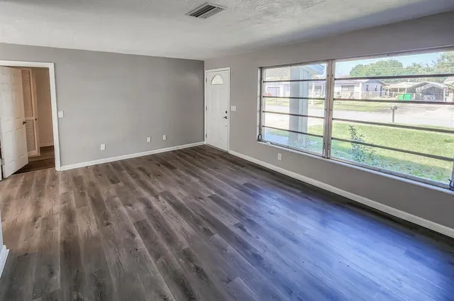 wooden floor in an empty room with a window