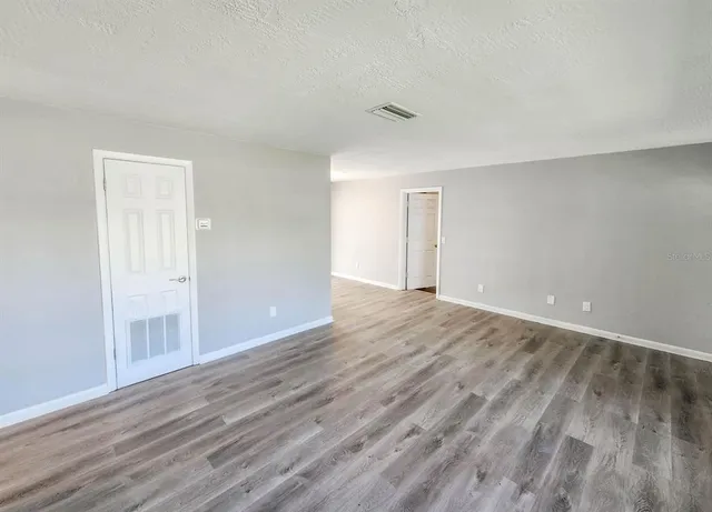 a view of an empty room and wooden floor