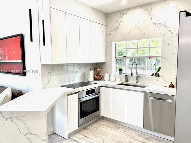 a kitchen with stainless steel appliances kitchen island granite countertop a refrigerator and a stove top oven