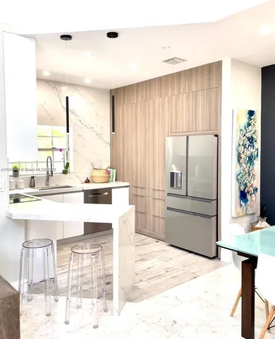 a view of a kitchen with kitchen island granite countertop a stove and a view of living room
