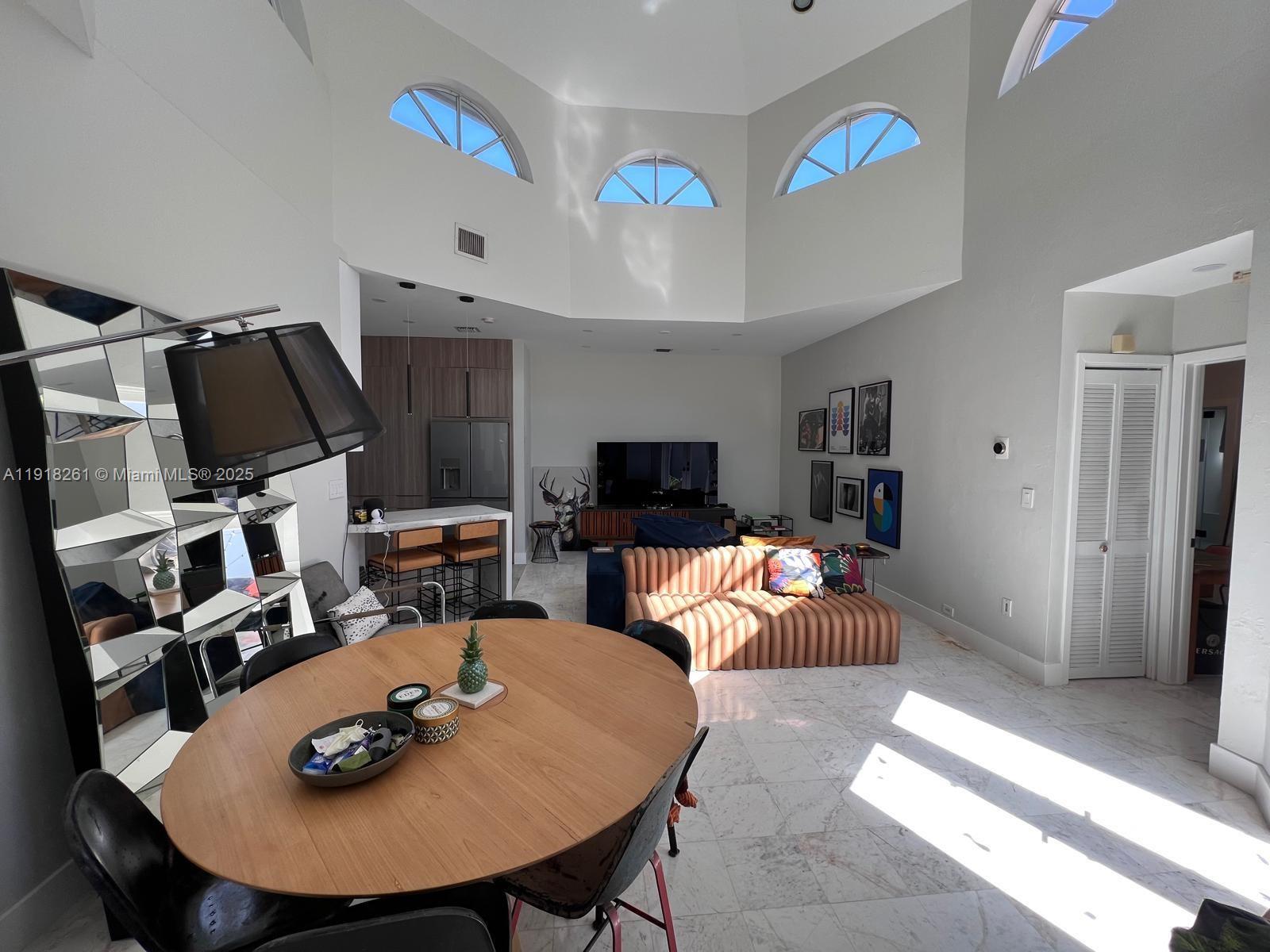 3070 Allamanda Street, Unit J Miami, FL 33133 - Photo 8 of 22 a living room with furniture and a flat screen tv