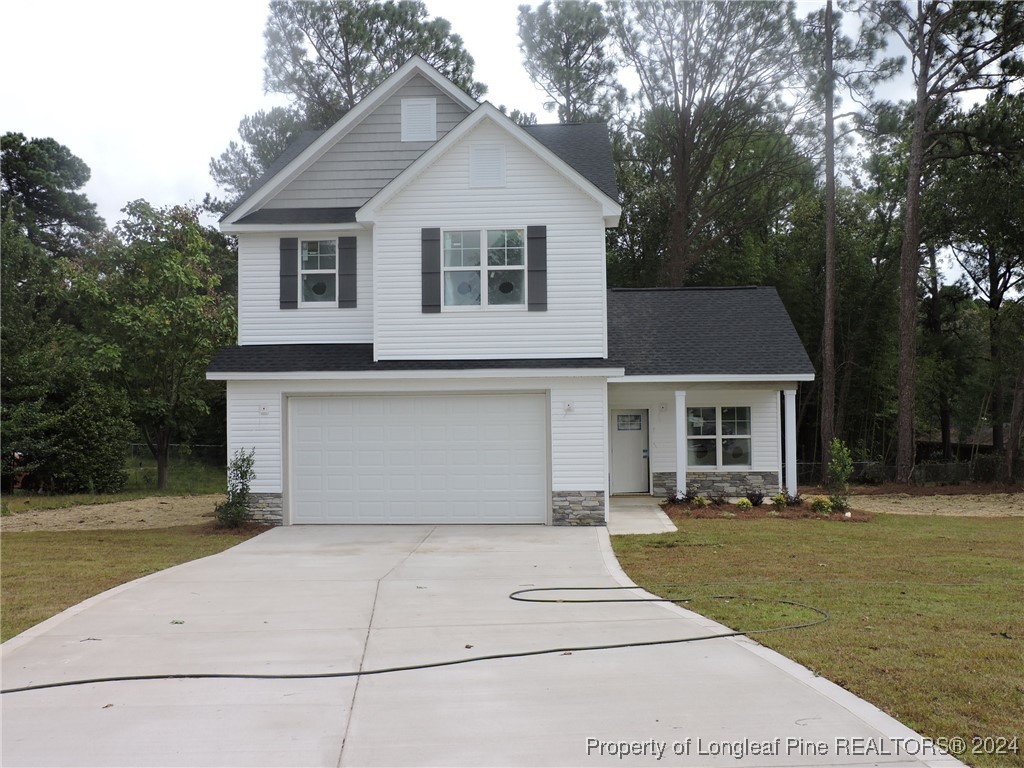 a front view of a house with a yard and trees