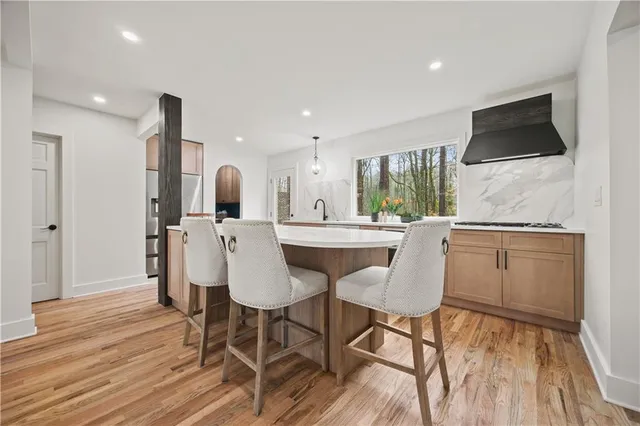 a view of kitchen with stainless steel appliances wooden floor and staircase
