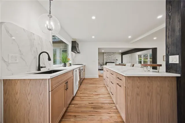 a large kitchen with kitchen island a sink stainless steel appliances and cabinets