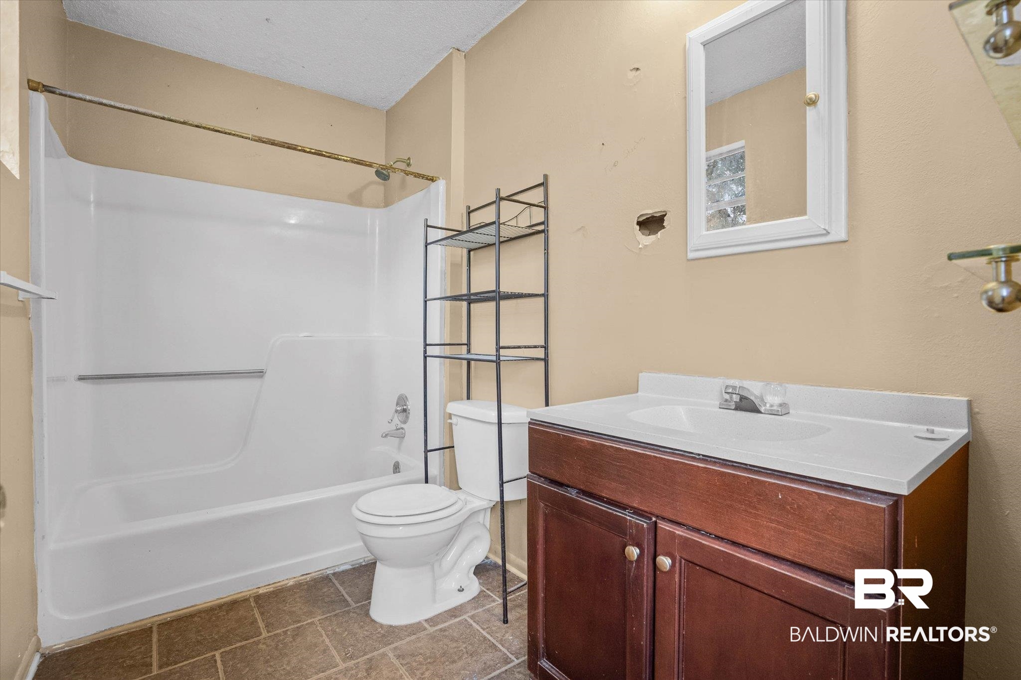 401 Frederick Avenue Fairhope, AL 36532 - Photo 10 of 36 Bathroom featuring a white bathtub/shower combination, a toilet, a dark wood-finish vanity with an integrated white sink, and neutral-toned wall paint