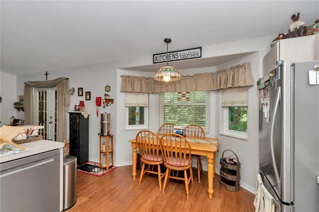 a dining room with furniture large window and wooden floor