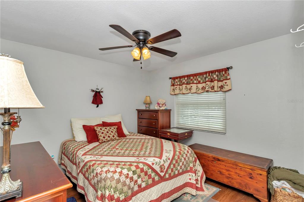 10086 Southwest 62nd Ter Road Ocala, FL 34476 - Photo 19 of 40 a bedroom with a bed and a chandelier