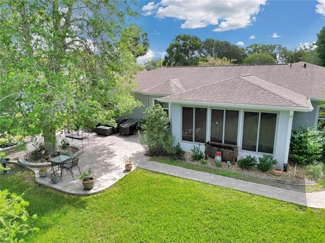 a view of a house with backyard sitting area and garden