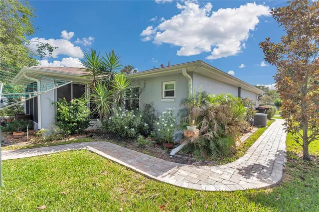 a view of a house with a yard fire pit and potted plants