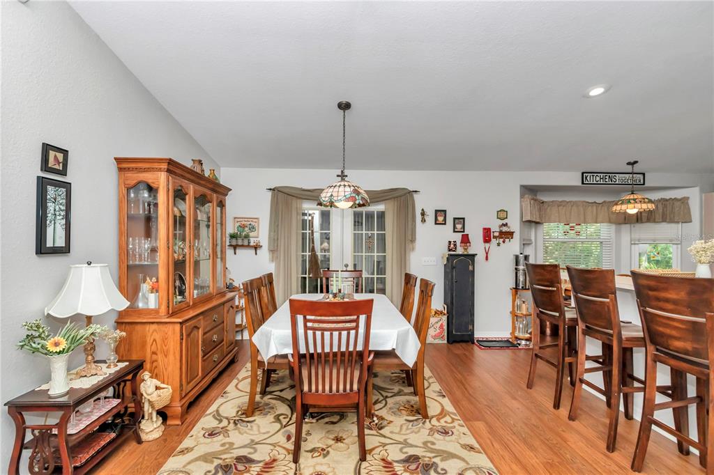 10086 Southwest 62nd Ter Road Ocala, FL 34476 - Photo 9 of 40 a dining room with furniture a chandelier and wooden floor