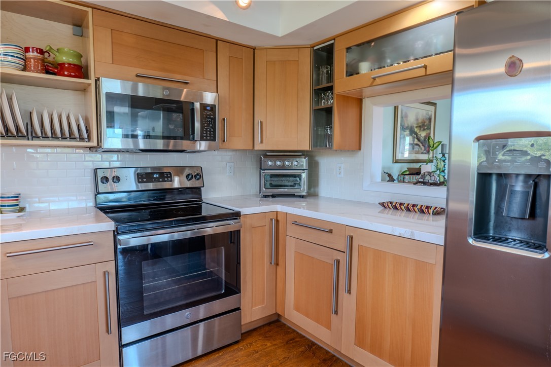 3315 Franzone Road St. James City, FL 33956 - Photo 11 of 37 a kitchen with stainless steel appliances granite countertop a stove and a microwave