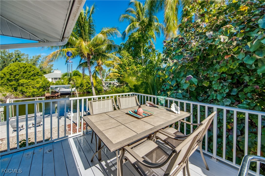 3315 Franzone Road St. James City, FL 33956 - Photo 16 of 37 a balcony with wooden floor and outdoor seating