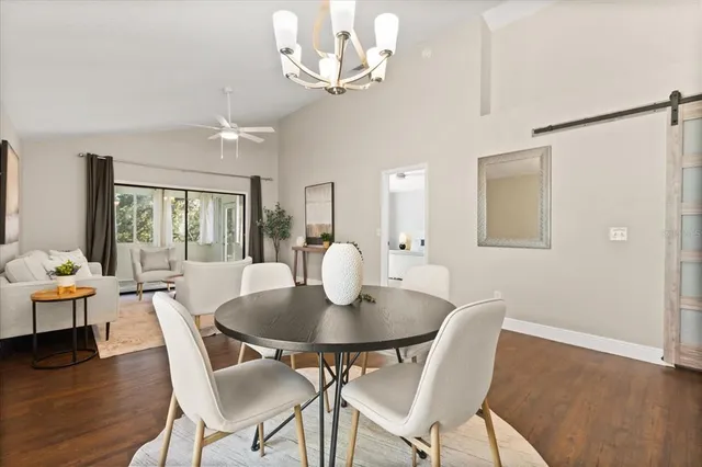 a view of a dining room with furniture a chandelier and wooden floor