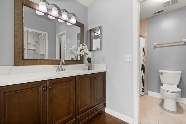 a bathroom with a sink a toilet a mirror and shower