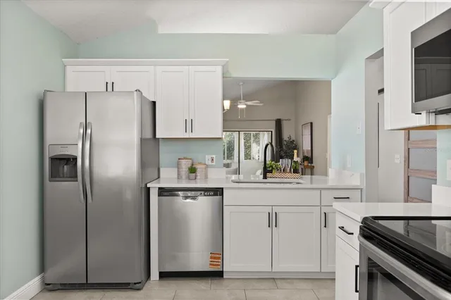 a kitchen with white cabinets and stainless steel appliances