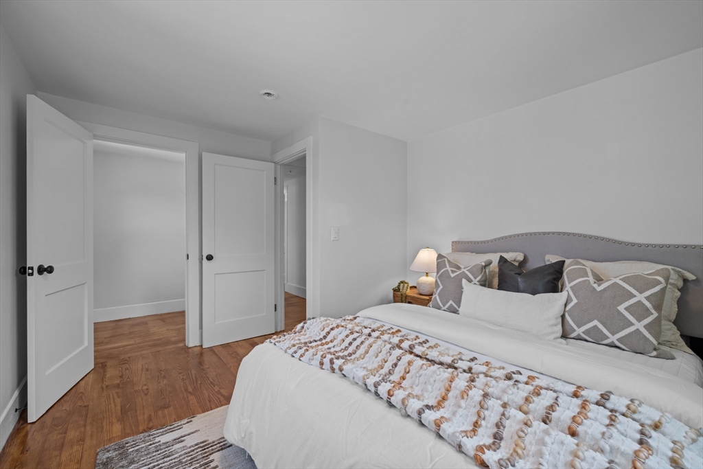 96 Alden Street Dedham, MA 02026 - Photo 21 of 38 a bedroom with a large bed and wooden floor