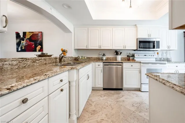 a kitchen with white cabinets sink and stainless steel appliances