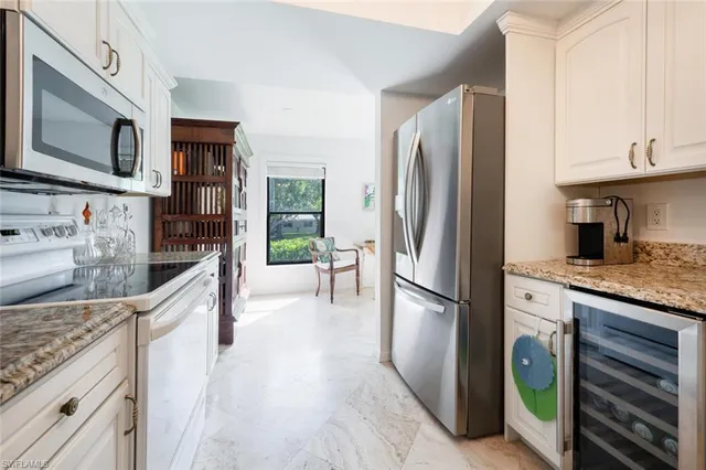 a kitchen with stainless steel appliances granite countertop a refrigerator a stove and a sink