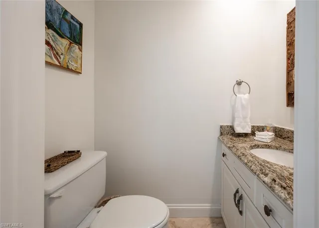 a bathroom with a granite countertop toilet sink and mirror