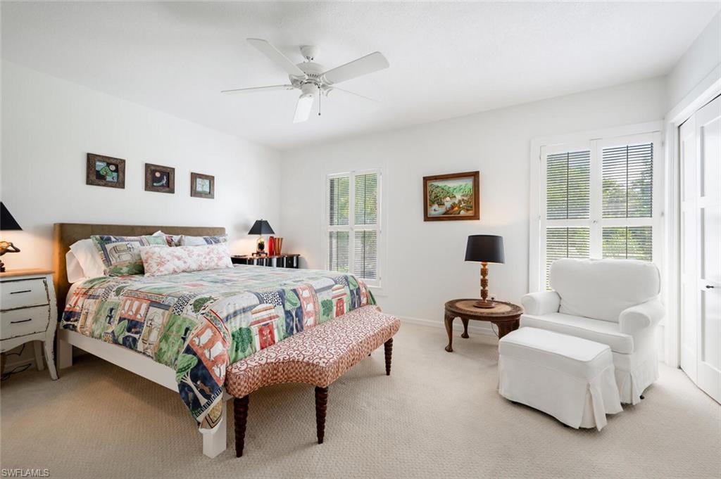 1080 6th Street South Naples, FL 34102 - Photo 28 of 33 a spacious bedroom with a bed and a couch