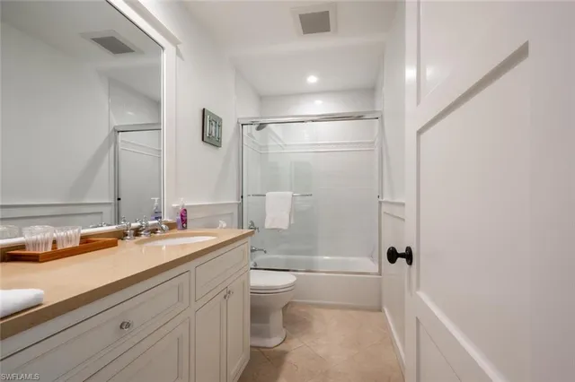 a bathroom with a sink a toilet and a large mirror