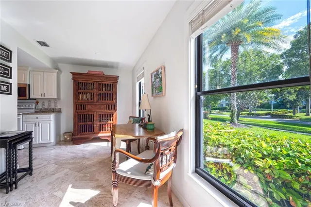a dining room with furniture and a floor to ceiling window