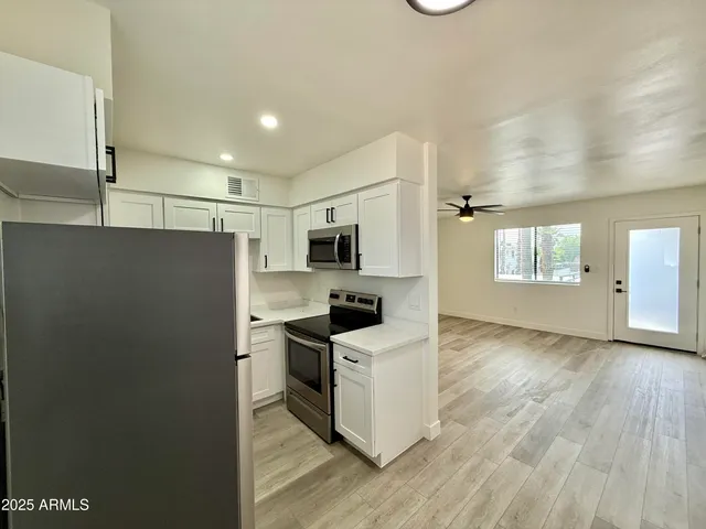 a kitchen with stainless steel appliances granite countertop a refrigerator and a stove top oven